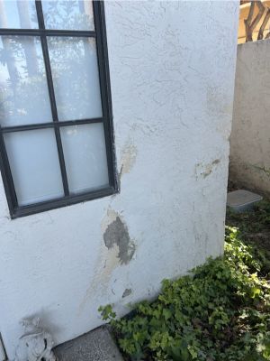 Earlier view of missing and damaged stucco below the same exterior window