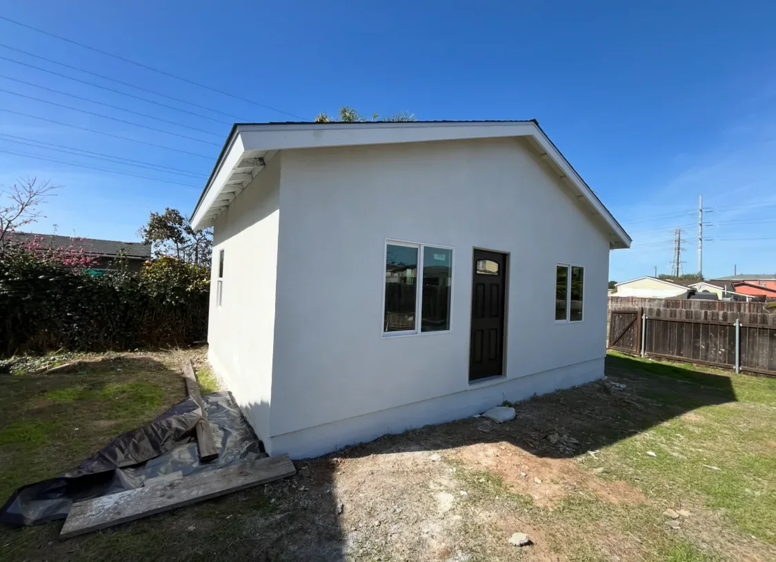Finished light-colored stucco exterior on a detached building